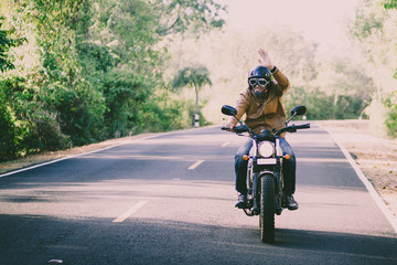 Obraz premium filter and grain photo ; man riding motorbike on a road in freedom lifestyle at vacation time
