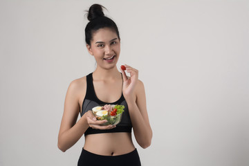 Portrait of attractive smiling woman eating salad isolated on white background.
