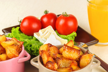 Breakfast from cheese, tomatoes, potatoes and all-over salad on a wooden table closeup.