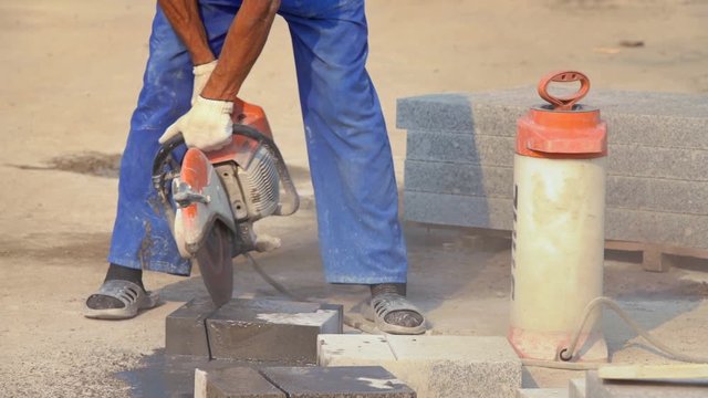 MOSCOW, RUSSIA, JULE 24, 2016: Construction Worker Cutting Concrete Block With Circular Saw