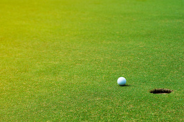 Golf ball on green near golf hole Concept of success, win	