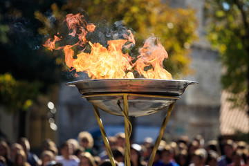 Flame lighting ceremony. Flame in front of blurred crowd