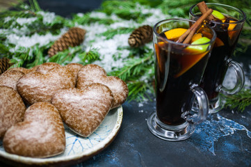 Christmas traditional mulled wine and gingerbreads in the form of heart. Christmas food composition on the background of fir-tree branches
