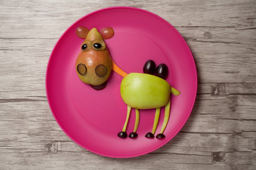 Camel made with fruits on plate and desk