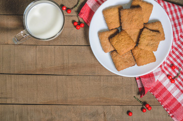 Biscuits, milk, red napkin, Christmas decor with free space for text. Top view