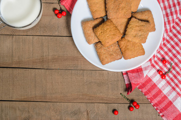 Biscuits, milk, red napkin, Christmas decor with free space for text. Top view