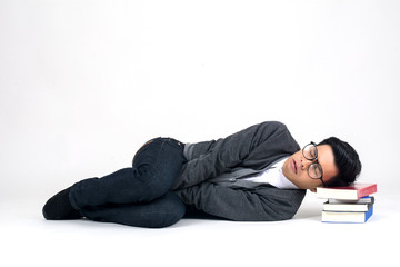 Playful happy young man funny round glasses lying with book over white background