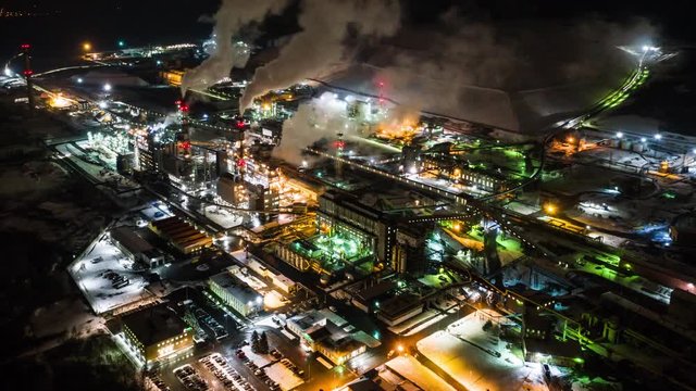 Aerial view of Oil refinery timalapse at night. Aerial footage.Oil refinery time lapse footage. Top view. Smokestacks from big pipes.