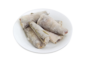 Carcasses of the frozen saltwater fish on white dish