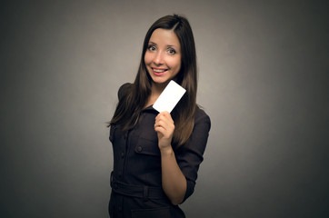 Happy smiling business woman holding in hand a blank visit card with copy space. Contact us.