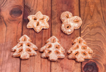 Festive gingerbreads in different shapes on a wooden surface