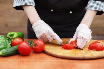 The cook cuts fresh farm vegetables