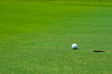 Golf ball on green near golf hole Concept of success, win