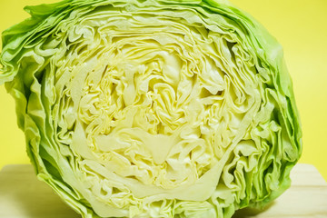 半分に輪切りにしたキャベツ　サラダ、食材、食物繊維イメージ　シンプル素材　黄色背景