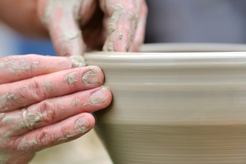 Obraz na płótnie Canvas Potter making ceramic pot on the pottery wheel