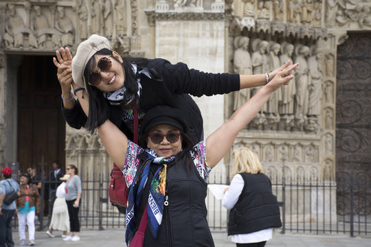 Asain women mother and daughter travel and posing for take photo with Cathedrale Notre-Dame de Paris