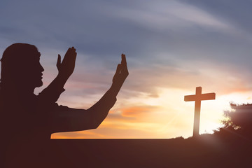 Silhouette man raising hand while praying to jesus