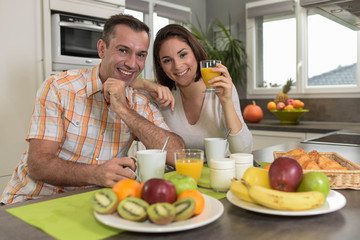 Cheerful  couple having vitamin breakfast in the kitchen