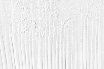 White abstract striped soft smooth crumbly plaster background with vertical folds.