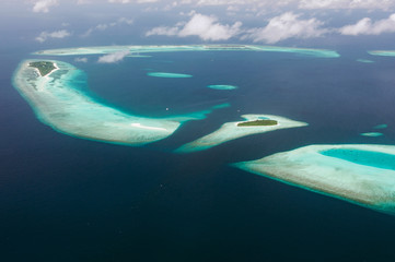 Tropical islands and atolls in Maldives in Indian Ocean from aerial view. Piece of paradise on the Earth. Good choice for vacation. Beautiful top view for wallpaper.