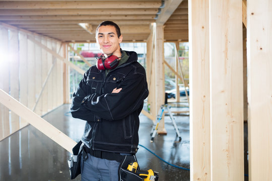 Handsome Carpenter Standing Arms Crossed At Site