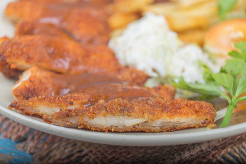 Chicken chop with vegetable and black pepper sauce in plate over wooden table