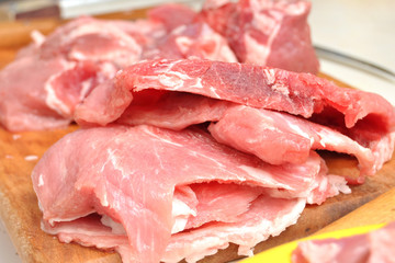 Raw chopped pork on the cutting board close-up. Process of cooking