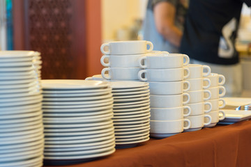 Plates and bowls, white ceramic on a brown tablecloth.