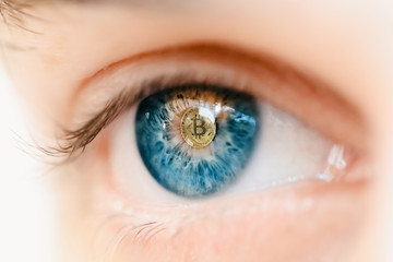 Bitcoin. Eye of a person with the bitcoin coin logo in the pupil