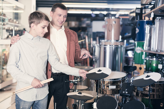 Boy and father choosing best drum