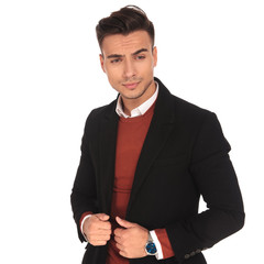 young man holding his coat's collars