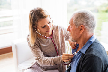 Health visitor and a senior man during home visit.