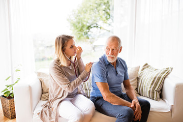Obraz premium Health visitor and a senior man during home visit.
