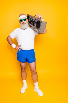 Crazy aged funny active sexy athlete pensioner grandpa in eyewear with bass clipping ghetto blaster recorder. Old school, swag, fooling around, gym, workout, technology, groove