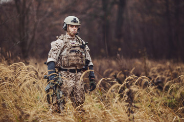 soldier with rifle in full gear. Military man on the background of nature.