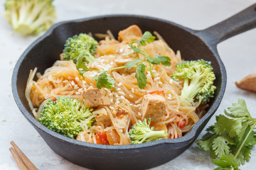 Fried vegan rice noodles with tofu and broccoli