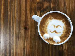 Cute cat face latte art coffee in white cup on wooden table ; love coffee, Cute Ne ko latte art coffee