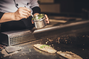 Hand of man take cooking of meat with vegetable grill, Chef cooking wagyu beef in Japanese teppanyaki restaurant