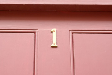 House number 1 sign on red painted door