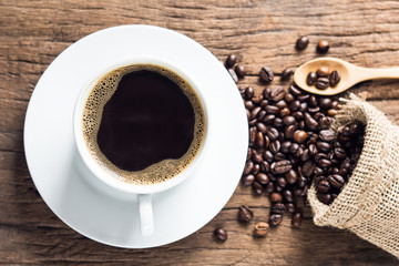 offee cup and beans on old wood background selective focus. Top view with copyspace for your text