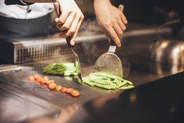 Hand of man take cooking of meat with vegetable grill, Chef cooking wagyu beef in Japanese teppanyaki restaurant
