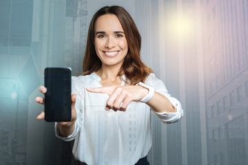 Cheerful woman pointing modern gadget