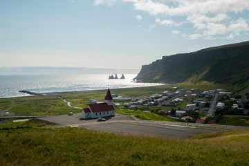 The view of Vik's church and city, Iceland and the famous black sand beach.