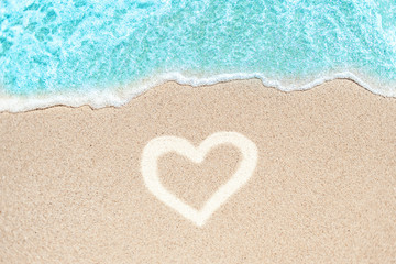 Fototapeta na wymiar Sea Beach and Sand in summer day with love heart shape sign on sand. Blue Ocean Wave Textured Background..