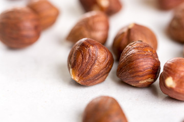 Closeup macro of raw hazelnuts on the white marble background