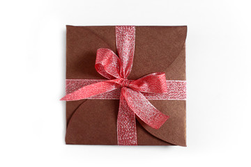 Christmas gift wrapped in brown paper with the bow top view isolated on white background