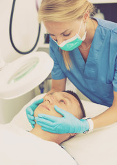 Obraz na płótnie Canvas Woman specialist is massaging skin of patient before the procedure