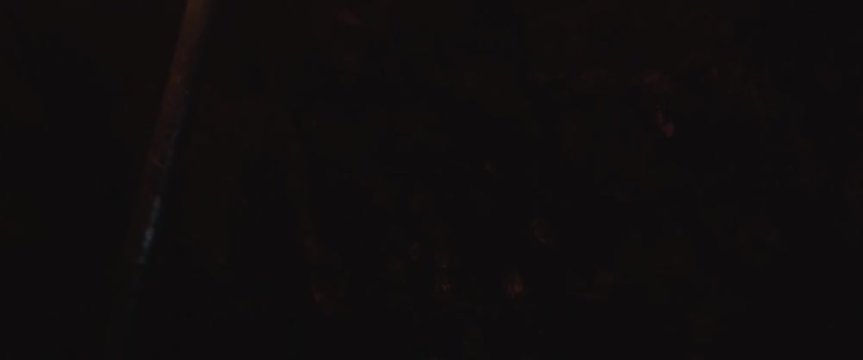 Torch ignites cave wall on fire with hand in the midst of the flames in super slow motion