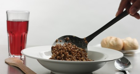 Delicious freshly made hot steaming chicken and lentil soup in a white wide-rimmed plate