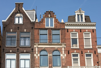 Fototapeta na wymiar Typical gabled houses on Damrak street in Amsterdam, Holland, Netherlands